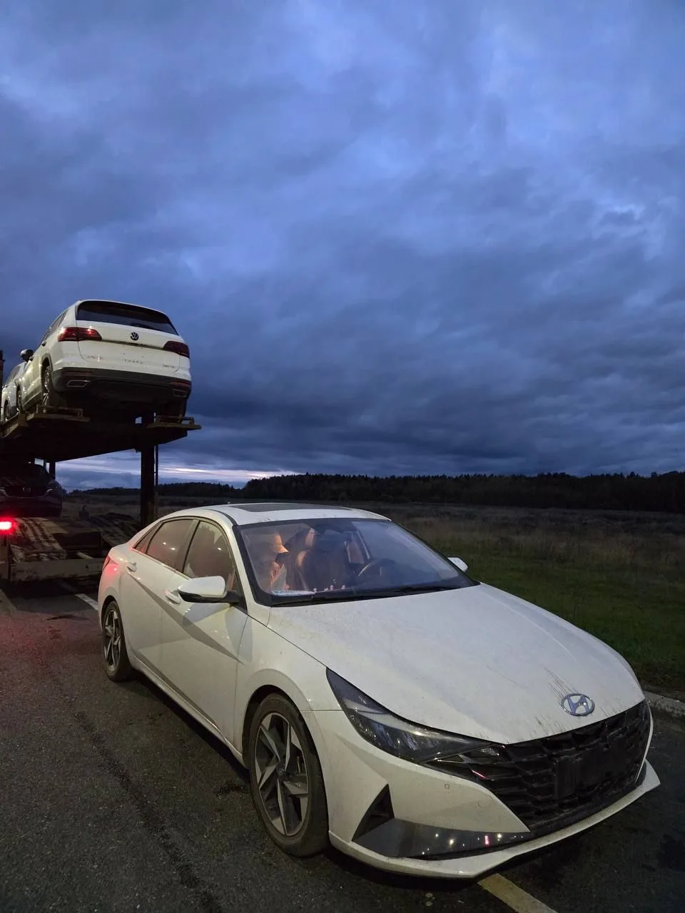 Hyundai Elantra вечером у дороги: вид спереди справа