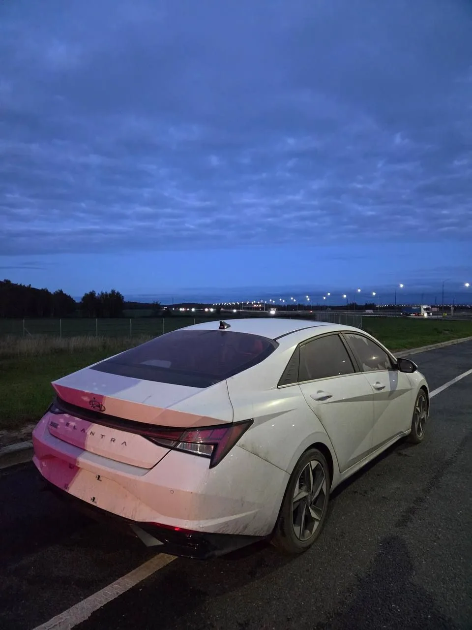 Hyundai Elantra вечером у дороги: вид сзади