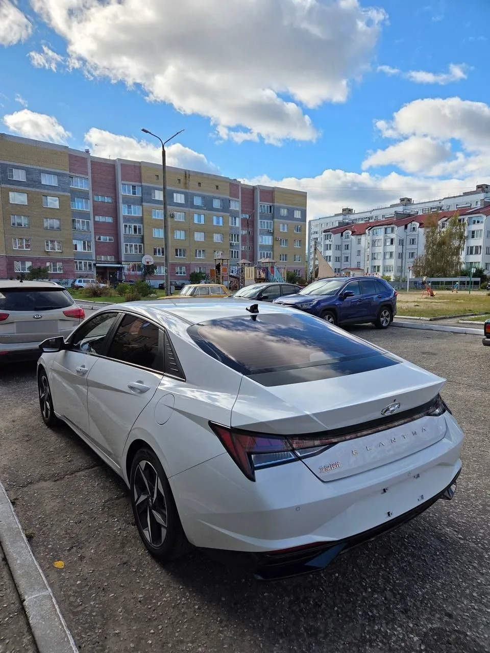 Hyundai Elantra на парковке во дворе: вид сзади слева